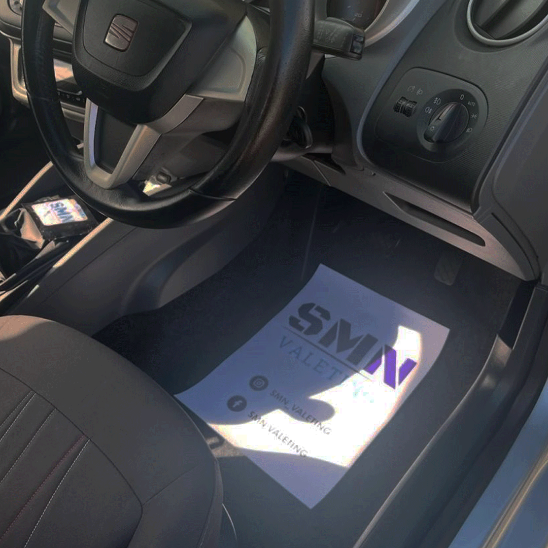 Custom-branded paper floor mat placed inside a car, offering a durable and stylish solution for automotive trade professionals.